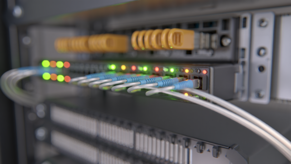 Professional network switch in a server rack with connected ethernet cables and active status lights.